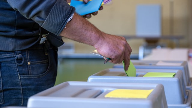 Ein Mann wirft seine Stimnzettel in die Wahlurne, um seine Stimmen abzugeben.