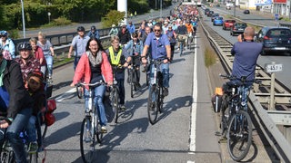 Zahlreiche Radfahrersind auf einer Straße unterwegs