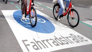 Zwei Fahrräder fahren über eine Straße mit dem Aufdruck "Fahrradstraße".