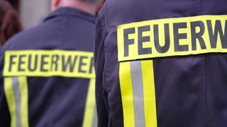 Die Jacken von Feuerwehleuten sind nebeneinander zu sehen