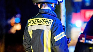 Der Schriftzug "Feuerwehr" steht auf der Jacke eines Feuerwehrmanns.