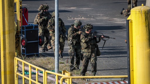 Soldaten des Heimatschutzes sichern beim Pressetag anlässlich der Bundeswehr-Übung "Fishtown Guard 2024" in Bremerhaven bei einer simulierten feindlichen Attacke