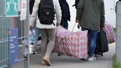 Flüchtlinge aus Syrien kommen mit ihrem Gepäck in einer Erstaufnahmeeinrichtung an.