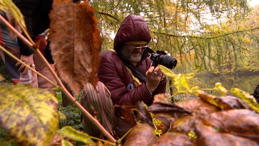 Ein Mann fotografiert in einem Park.