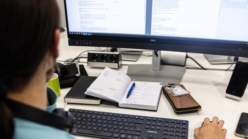 Eine Frau sitzt in einem Büro an einem PC und arbeitet (Symbolbild)