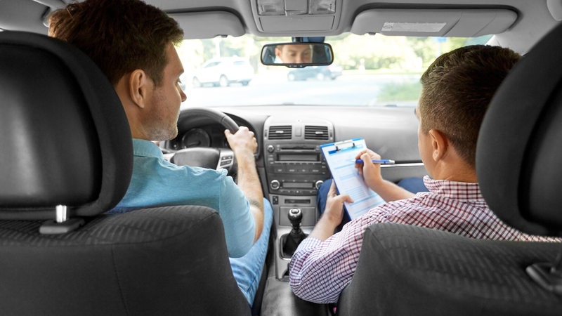 Zwei Menschen sitzen in einem Auto.