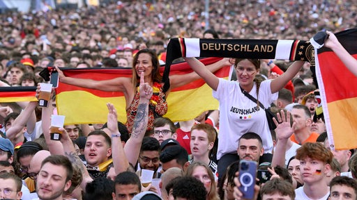 Fußballfans feiern während eines Deutschland-Spiels auf dem Fanfest in Berlin.