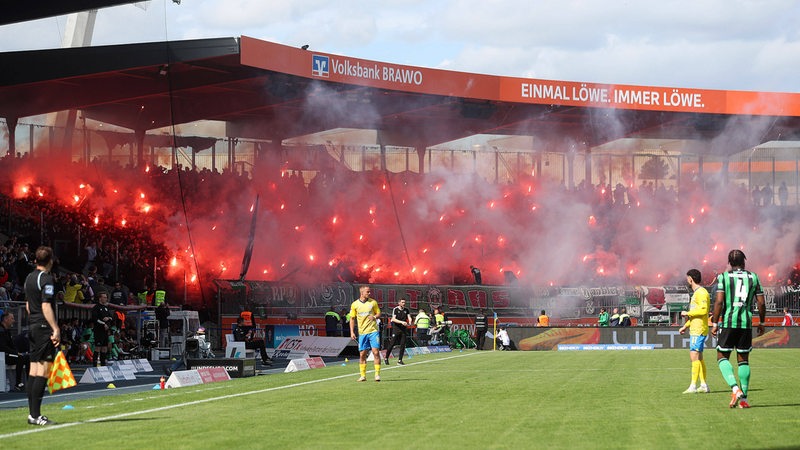 Hannovers Fans zünden unzählige Pyrofackeln im Gästeblock des Braunschweiger Stadions.