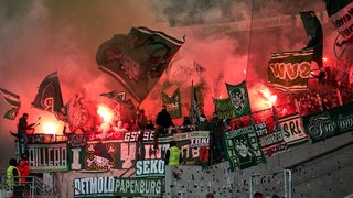 Werder-Ultras haben im Gästeblock des Stuttgarter Stadions hell leuchtende Pyrotechnik entzündet.