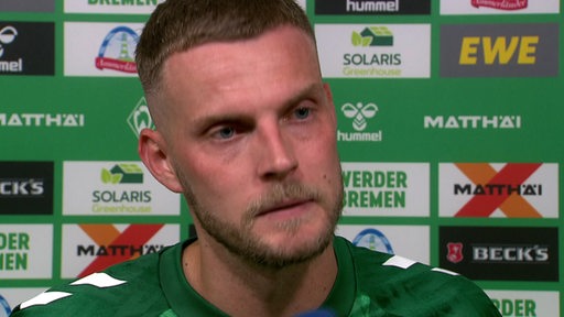 Werder-Stürmer Marvin Ducksch beim Interview nach dem Spiel vor einer Werbewand.