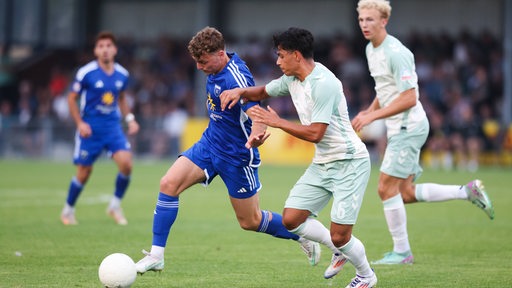 Fußballspieler von Werder Bremen II im Zweikampf mit einem Gegenspieler von Kickers Emden