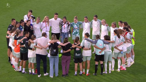 Die Spielerinnen der Bundesliga-Frauenmannschaft Werder Bremen stehen in einem Kreis auf dem Spielfeld.