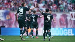 Werder-Spieler Nick Woltemade klatscht mit seinem Teamkollegen Leonardo Bittencourt ab.