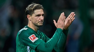 Werder-Profi Niklas Stark applaudiert nach einem Spiel den Fußball-Fans.