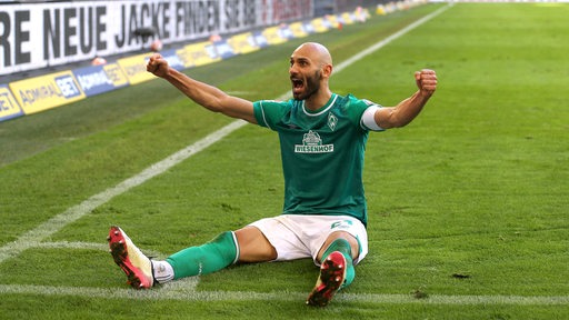 Ömer Toprak vom SV Werder sitzt auf dem Rasen und jubelt.