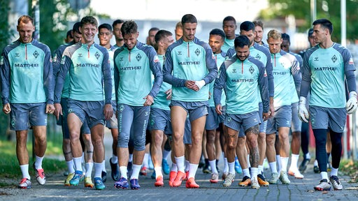 Die Fußballspieler von Werder Bremen sind gemeinsam auf dem Weg zum Trainingsplatz.