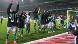 Die Werder-Spieler hüpfen aufgereiht nebeneinander vor der Ostkurve im Weser-Stadion und bejubeln ihren Sieg gegen Union Berlin.