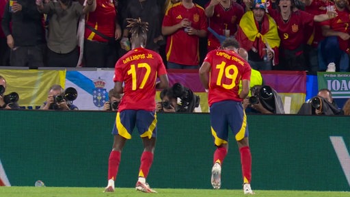 Zwei Spieler der Spanischen Nationalmannschaft jubeln vor Publikum