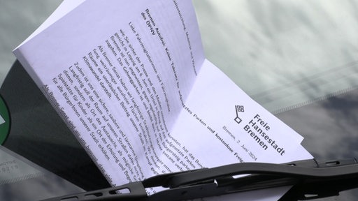 Ein Brief, mit dem Siegel der Freien Hansestadt Bremen, klemmt unter dem Scheibenwischer eines Autos.