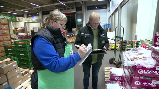 Gemüsebauer Björn True und seine Schwester Inga in einer großen Halle mit Gemüse.