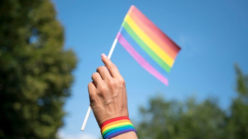 Regenbogenflagge wird geschwenkt (Symbolbild)