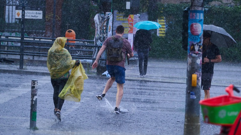 Fußgänger laufen bei starkem Regen durch die Stadt