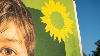 Die Ecke eines Wahlplakats der Grünen mit Sonnenblume ist zu sehen.