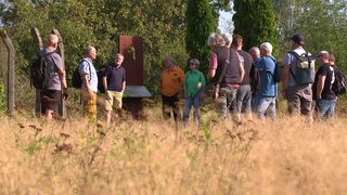 Eine Gruppe von Personen steht auf einem Feld