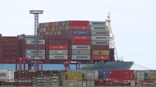 Ein mit Containern beladenes Frachtschiff in einem Hafen