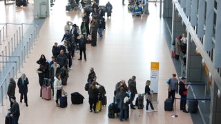 Menschen stehen Schlange am Hamburger Flughafen