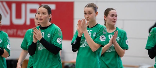 Werders Zweitliga-Handballerinnen stehen enttäuscht nach einem Spiel da und applaudieren ihren Fans.