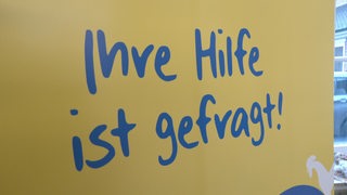 Ein Poster mit der Aufschrift "Ihre Hilfe ist gefragt!"