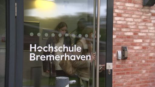 Studierende gehen durch eine Tür der Hochschule Bremerhaven