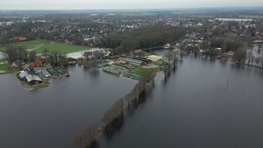 Ein Landwirtschaftlicher Betrieb ist umgeben von überfluteten Wiesen.