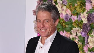 Der Filmstar Hugh Grant lächelt auf einer Filmpremiere.