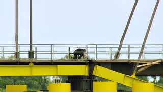 Ein Mann kontrolliert Schäden an der Huntebrücke nach dem Unfall.