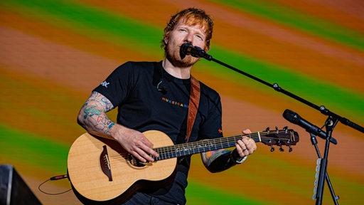 Ed Sheeran steht auf der Bühne.