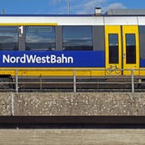 Ein Regionalexpress der Nordwestbahn steht auf einer Eisenbahnbrücke.