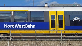 Ein Regionalexpress der Nordwestbahn steht auf einer Eisenbahnbrücke.