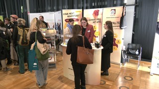 Stände mit unterschiedlichen Angeboten für Menschen mit Behinderung auf der inklusiven Ausbildungs- und Jobmesse.