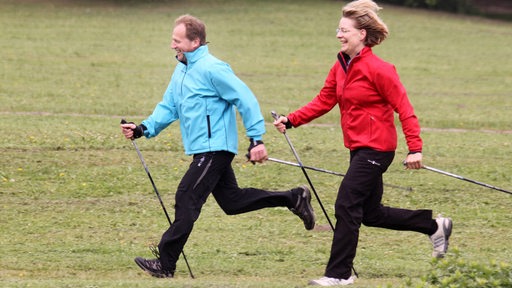 Ein Mann und eine Frau beim Walken im Freien