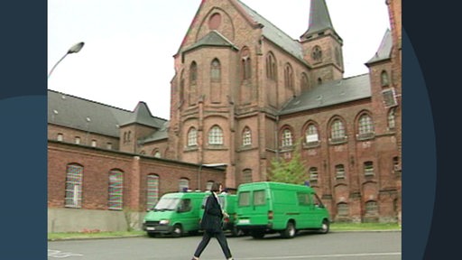 Eine Person läuft vor dem JVA-Gebäude in Bremen Oslebshausen.