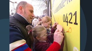 Kinder und Erwachsene malen auf einem Plakat