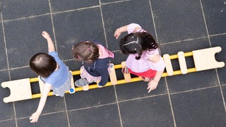 Kinder balancieren auf einer Leiter