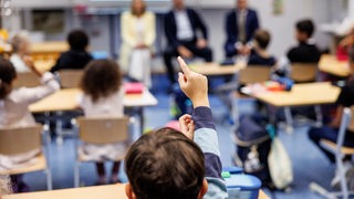 Politiker zu Besuch in einer Grundschulklasse, die Fragen der Schüler beanworten