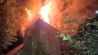 Ein Kirchturm steht in Brand.