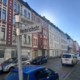 Blick in eine Straße mit Mehrfamilienhäusern. Auf den beiden Straßenschildern stehen "Körnerstraße" und "Heinrichstraße".