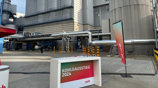 Kohlekraftwerk in Bremen-Hasted, im Vordergrund ein Tresen mit einem Knopf, auf dem Kohleausstieg 2024 steht
