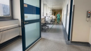 Eine Person läuft über einen Flur in einem Krankenhaus.