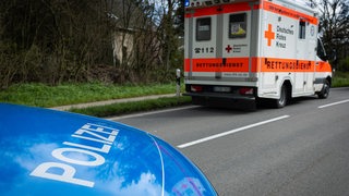 Ein Einsatzfahrzeug, Streifenwagen, der Polizei steht mit Blaulicht und Schriftzug als Straßensperre auf einer Landstraße.